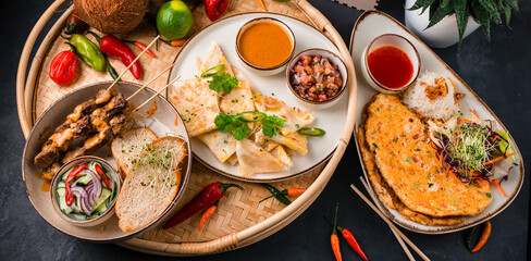 Set of restaurant dishes: beef kebab, omelette with tomatoes and onions, flatbread with cheese filling.