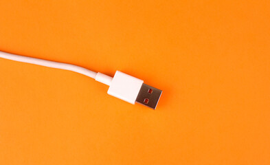 White usb cable on orange background
