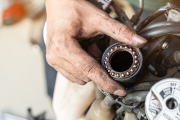 Mechanic inspect and adjust Motorcycle Steering Head Bearings, maintenance, repair motorcycle concept in garage .selective focus