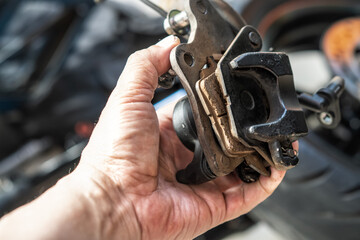 mechanic Replace and adjust motorcycle Brake system, brake pad. maintenance, repair motorcycle concept in garage .selective focus