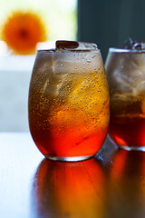 Cold cocktail. Summer soft drink with ice based on orange juice and syrup in a glass.