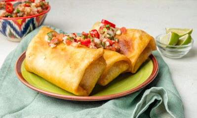 A plate with a Mexican snack chimichanga, a traditional spicy dish.