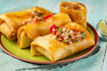 Chimichanga close-up, tortilla stuffed with minced beans and spices, several pieces. Traditional Mexican food.