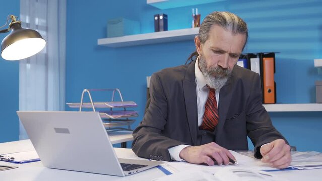 Middle-aged mature businessman at his desk in the office thinking of creative and genius ideas and drawing on the project.
