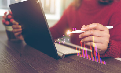 Accountant working with pen on graphs on tablet