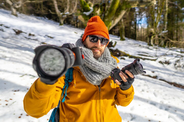 Fototapeta na wymiar Portrait of a photographer trekking with backpack with two cameras in hand winter hobby