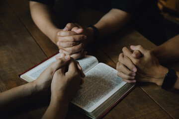 Christians and Bible study concept. Christians held each other's hands praying together and seeking the blessings of God,  They were reading the Bible and sharing the gospel. praying worship believe.