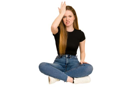 Young redhead woman sitting on the floor cut out isolated forgetting something, slapping forehead with palm and closing eyes.