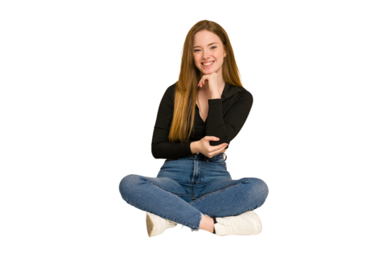Young redhead woman sitting on the floor cut out isolated cheering carefree and excited. Victory concept.