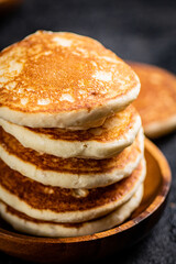 A pile of homemade pancakes in a plate on the table. 