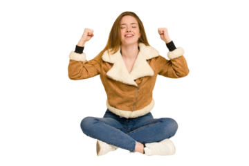 Young redhead woman sitting on the floor cut out isolated shocked, covering mouth with hands, anxious to discover something new.