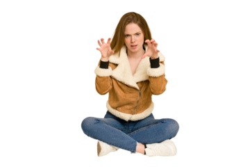 Young redhead woman sitting on the floor cut out isolated having a strong teeth pain, molar ache.