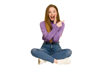 Young redhead woman sitting on the floor cut out isolated laughs joyfully keeping hands on head. Happiness concept.