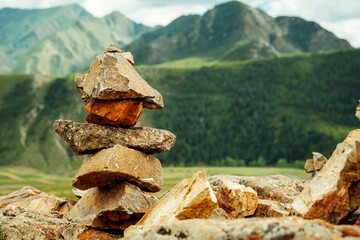 Ritual stone pyramids in Altai mountains, Siberia.  Rocky cairns overlooking the hills overgrown with green forest. Zen-like natural landscape.