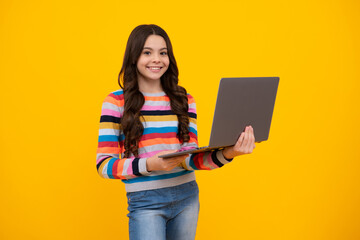 School student using laptop. E-learning and online education. Teen girl on internet video chat isolated on isoalted yellow background. Happy teenager, positive and smiling emotions of teen schoolgirl.
