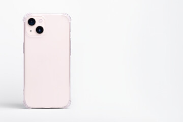 Pink iPhone 13 in clear transparent soft silicone case back view. Phone case mockup isolated on gray background. Banner with place for text on the right
