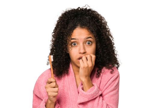 Young african american curly woman after shower toothbrushing isolated biting fingernails, nervous and very anxious.