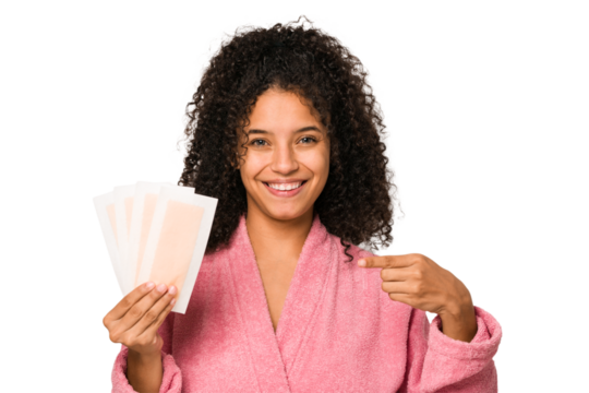 Young african american curly woman holding an hair removal bands isolated person pointing by hand to a shirt copy space, proud and confident