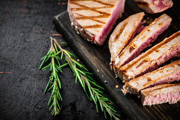 Grilled tuna on a cutting board.