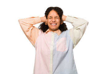 Young african american curly woman isolated covering ears with hands trying not to hear too loud sound.