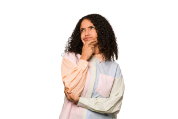 Young african american curly woman isolated thinking and looking up, being reflective, contemplating, having a fantasy.