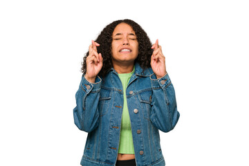 Young african american curly woman isolated crossing fingers for having luck