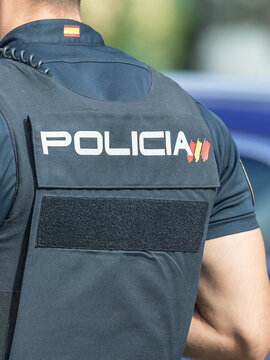 National Police officer. Spanish policeman dressed in uniform and with a bulletproof vest. Close-up of the national policeman from behind. Madrid, Spain.