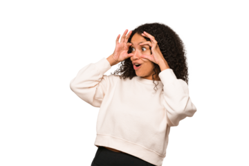 Young african american curly woman isolated keeping eyes opened to find a success opportunity.