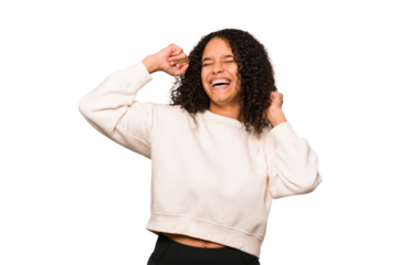 Young african american curly woman isolated celebrating a special day, jumps and raise arms with energy.
