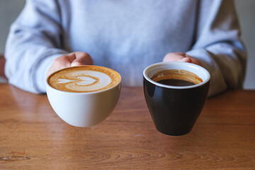 Closeup image of a woman holding and serving two cups of hot coffee