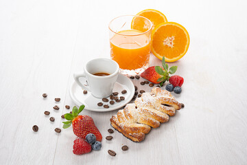 breakfast with espresso coffee, brioches, orange juice and fresh fruit on a light background