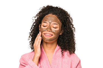 Young african american curly woman wearing a bathrobe and a facial mask isolated