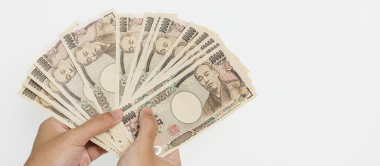 man hand holding Japanese Yen banknote stack. Thousand Yen money. Japan cash, Tax, Recession Economy, Inflation, Investment, finance and shopping payment concepts