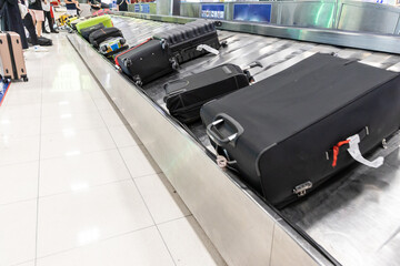 Baggage luggage at airport arrival carousel with passengers awiating to claim theirs