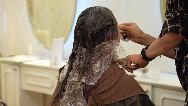 女性にメイクをする男性美容師