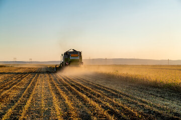 Naklejka premium The hard work of harvesting, a farmer in a combine harvester at work in a soybean field
