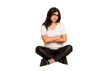 Young indian woman sitting on the floor cut out isolated suspicious, uncertain, examining you.