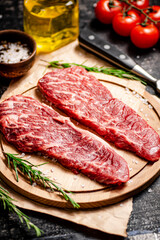 Raw steak on a wooden cutting board. 