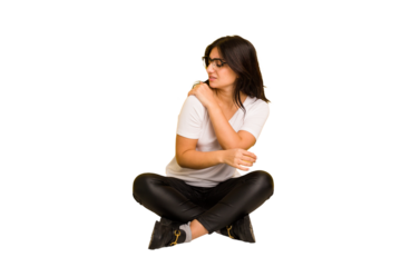 Young indian woman sitting on the floor cut out isolated having a shoulder pain.