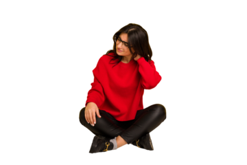 Young indian woman sitting on the floor cut out isolated suffering neck pain due to sedentary lifestyle.