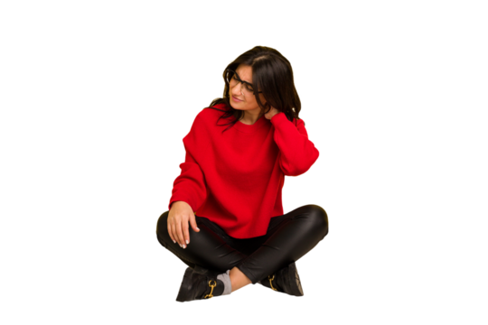 Young indian woman sitting on the floor cut out isolated suffering neck pain due to sedentary lifestyle.