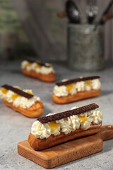 Classic éclairs adorned with dark chocolate bars, the whipped cream filling creating a tempting contrast with the rich topping.
