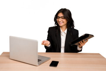Young indian woman in a table with a laptop and tablet using a mobile phone isolated