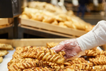Kunde packt Schinkenstangen in Plastikbeutel