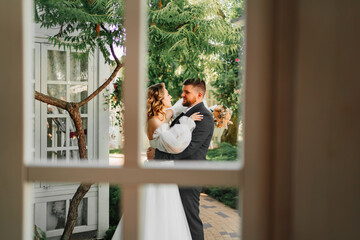 Obraz premium view through the window of a loving couple of newlyweds in the park. 