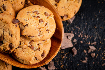 Wooden plate with cookies and pieces of milk chocolate. 