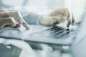Multi exposure of abstract creative digital world map and hand typing on computer keyboard on...