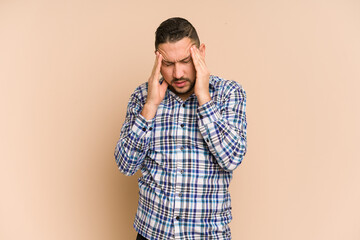 Adult latin man cut out isolated having a head ache, touching front of the face.