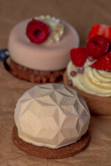 three delicious cakes with fruit on brown paper, large photo