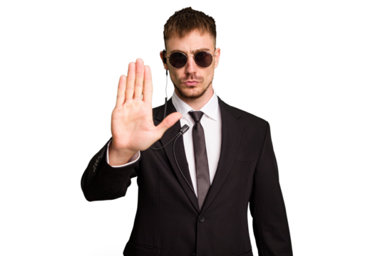 Security bodyguard man wearing a suit isolated cut out standing with outstretched hand showing stop sign, preventing you.